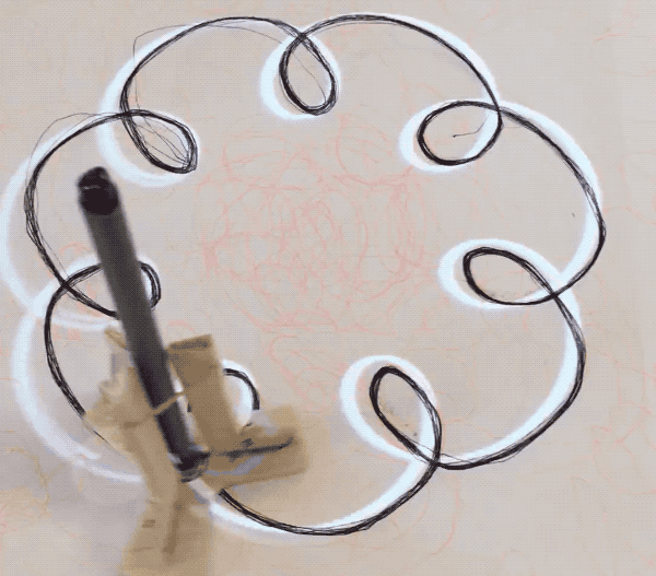A pen drawing on its own, sketching a spiral shape.