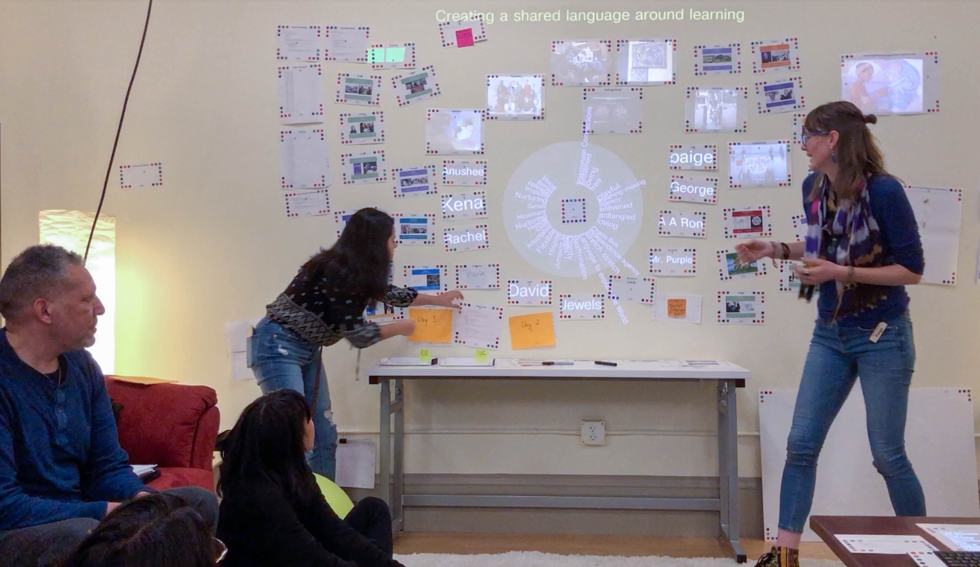 Two people standing in front of a wall presenting with dynamic media attached to the walls